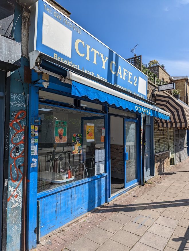 The blue shopfront of City Cafe 2 seen from the pavement